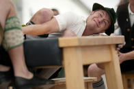 A man dressed in traditional clothes tries to pull his opponent over the table at the German Championships in Fingerhakeln or finger wrestling, in Bernbeuren, Germany, Sunday, May 12, 2024. Competitors battled for the title in this traditional rural sport where the winner has to pull his opponent over a marked line on the table. (AP Photo/Matthias Schrader)