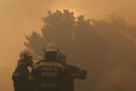 Firefighters keep an eye on a raging fire on the slopes of Table Mountain, in Cape Town South Africa, Monday, April 19, 2021. Residents are being evacuated from Cape Town neighborhoods after a huge fire spreading on the slopes of the city’s famed Table Mountain was fanned by strong winds overnight and houses came under threat. City authorities say residents of parts of the Vredehoek neighborhood were being evacuated Monday as a “precautionary” measure after the fire spread towards the area. (AP Photo/Nardus Engelbrecht)