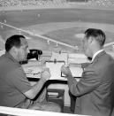 FILE - Allan Roth, left, statistician of the Los Angeles Dodgers, sits in the booth with broadcaster Vin Scully in August 1963 in Los Angeles. Scully, whose dulcet tones provided the soundtrack of summer while entertaining and informing Dodgers fans in Brooklyn and Los Angeles for 67 years, died Tuesday night, Aug. 2, 2022, the team said. He was 94. (AP Photo/Harold Filan, File)