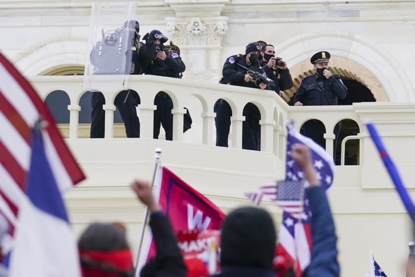 Supporters loyal to President Donald Trump clash with authorities before successfully breaching the Capitol building during a riot on the grounds, Wednesday, Jan. 6, 2021. A number of lawmakers and then the mob of protesters tried to overturn America's presidential election, undercutting the nation's democracy by attempting to keep Democrat Joe Biden from replacing Trump in the White House. (AP Photo/John Minchillo)