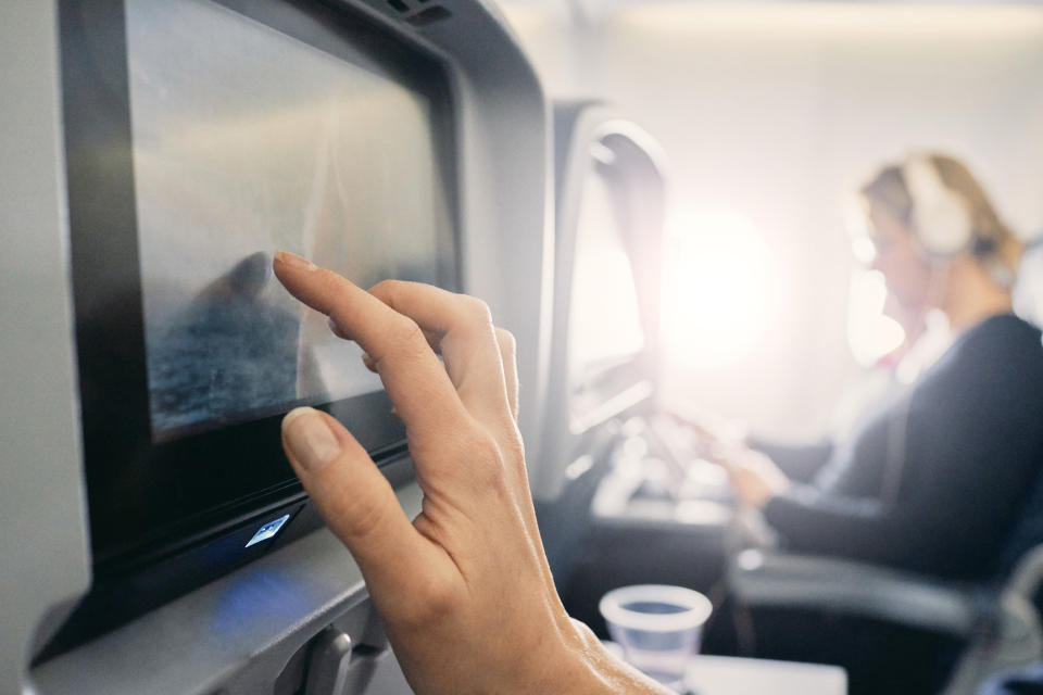 A traveler watching an in-flight movie