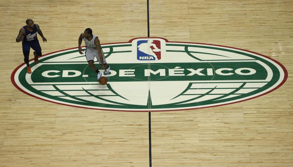 San Antonio Spurs forward Kawhi Leonard dribbles past half-court against the Phoenix Suns' P.J. Tucker during a game in Mexico City, on Jan. 14, 2017. (AP)