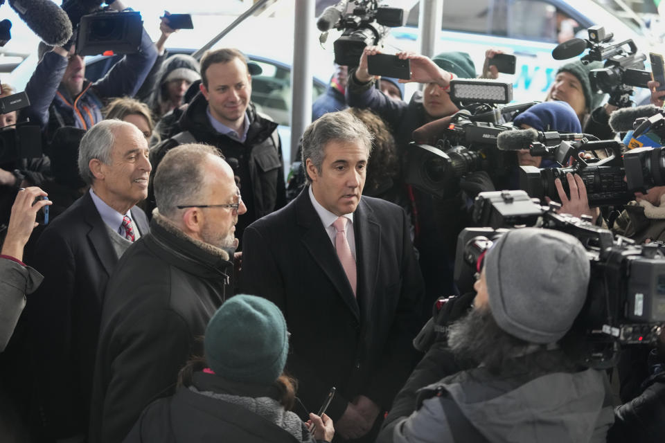 Michael Cohen, center, is surrounded by reporters as he arrives with his attorney Lanny Davis, left, for the second day of grand jury testimony, Wednesday, March 15, 2023, in New York. (AP Photo/Mary Altaffer)