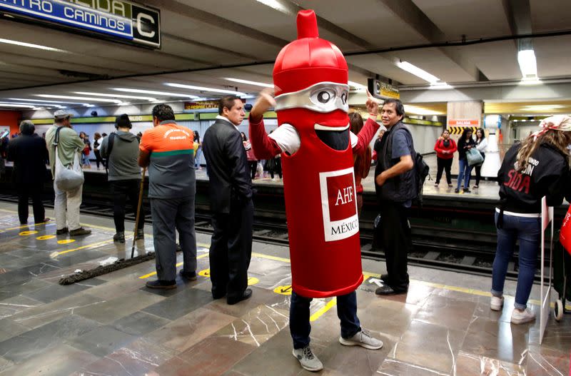 A man wearing a costume, representing a condom, is seen at a metro station, on the International Condoms Day, celebrated a day before Valentine Day, in Mexico City