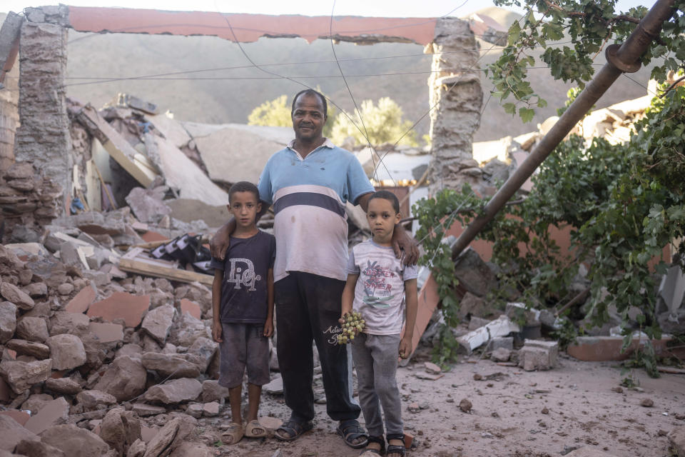 Mohammed Elhmatif and his sons, Rayan, right, and Ali, stand amidst the rubble of their home which was damaged by the earthquake, in Ijjoukak village, near Marrakech, Morocco, Saturday, Sept. 9, 2023. A rare, powerful earthquake struck Morocco, sending people racing from their beds into the streets and toppling buildings in mountainous villages and ancient cities not built to withstand such force. (AP Photo/Mosa'ab Elshamy)