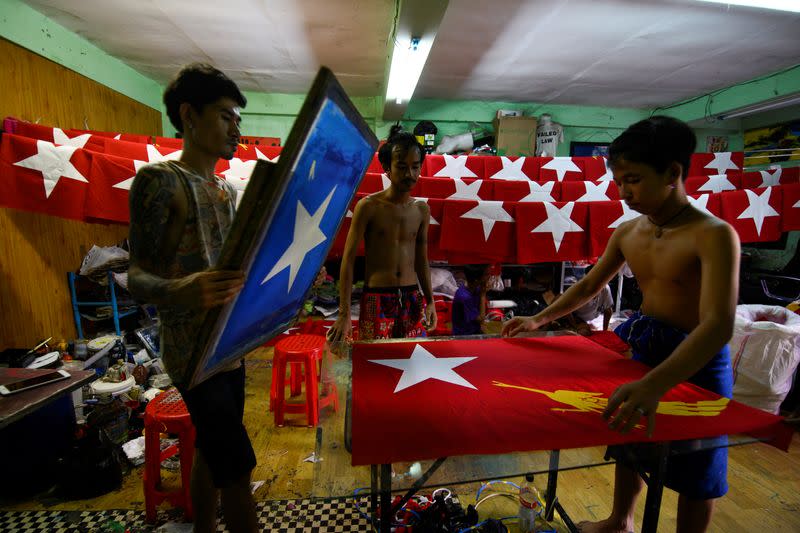 Workers print a flag with the logo of Aung San Suu Kyi's National League for Democracy NLD party in Yangon