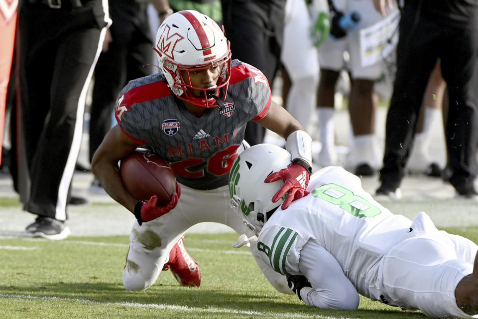 Miami (Ohio) running back Kevin Davis (26) is tackled by North Texas defensive back John Davis Jr. (8) in the first half of the Frisco Football Classic NCAA college football game in Frisco, Texas, Thursday, Dec. 23, 2021. (AP Photo/Matt Strasen)
