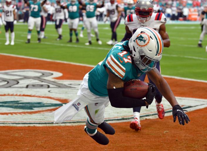 Miami Dolphins wide receiver Jaylen Waddle (17) scores a touchdown over New England Patriots cornerback J.C. Jackson (27) in the first quarter at Hard Rock Stadium in Miami Gardens, Jan. 9, 2022. 