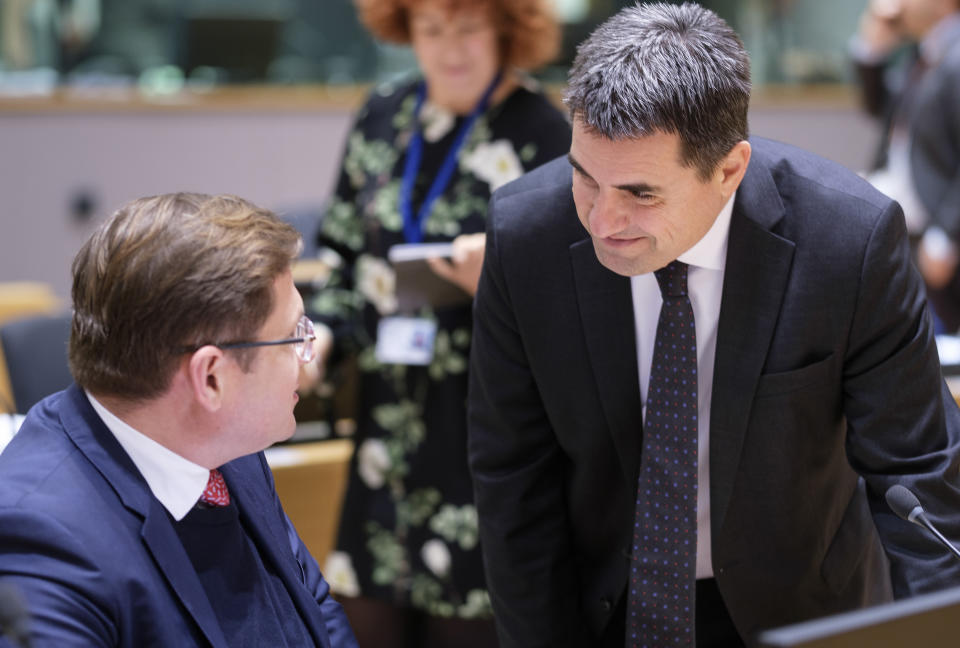 Poland's Permanent Rep to the EU Andrzej Sados, left, speaks with Hungary's Deputy Permanent Representative to the EU Tibor Stelbaczky during a meeting of EU interior ministers at the European Council building in Brussels, Friday, March 13, 2020. European Union interior ministers on Friday were trying to coordinate their response to the novel coronavirus as the number of cases spreads throughout the 27-nation bloc and countries take individual measures to slow the disease down. For most people, the new coronavirus causes only mild or moderate symptoms, such as fever and cough. For some, especially older adults and people with existing health problems, it can cause more severe illness, including pneumonia. (AP Photo/Thierry Monasse)