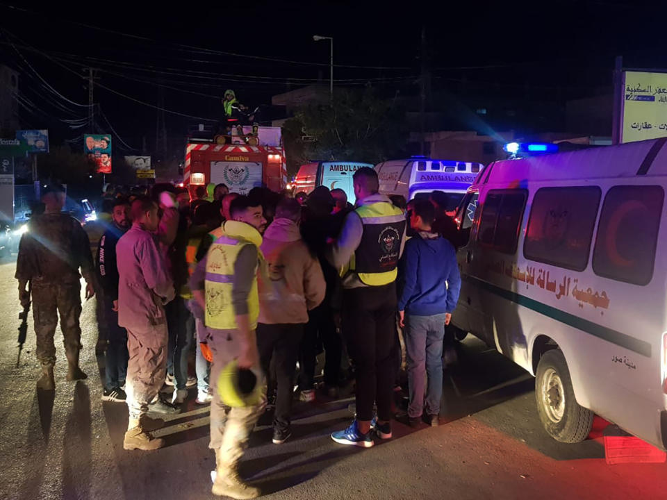 Lebanese rescue workers gather next to their ambulances at the main entrance of Burj Shamali Palestinian refugee camp, in the southern port city of Tyre, Lebanon, Friday, Dec. 10, 2021. Arms stored for the Palestinian Hamas group exploded in a refugee camp in southern Lebanon on Friday night, killing and wounding a number of people, the state-run National News Agency reported. (AP Photo/Mohammed Zaatari)