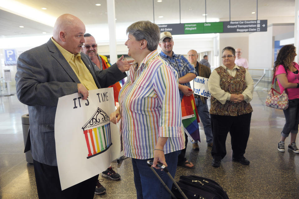 From left, Toby Jenkins speaks with Sharon Baldwin before Baldwin boarded a plane to Denver, Wednesday April 16, 2014. Oklahomans for Equality gathered at Tulsa International Airport with their signs for a send off celebration in support for the plaintiffs, including Sharon Baldwon, in the Oklahoma Marriage Equality lawsuit as they head to the 10th Circuit Court of Appeals in Denver. (AP Photo/Brandi Simons)