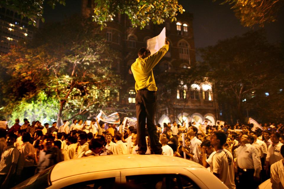 A man holds a sign on top of a car