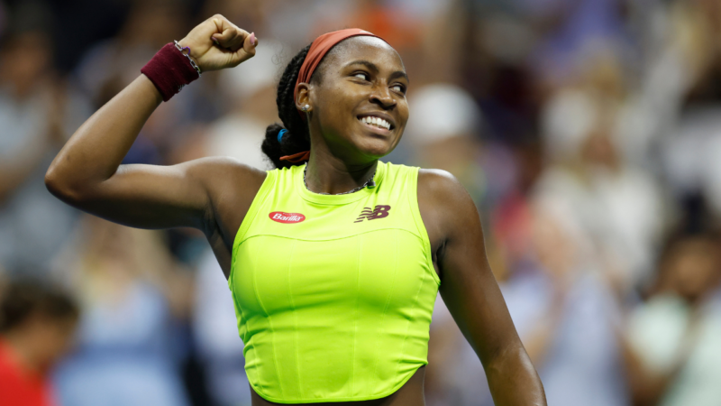 Learn all about star tennis player Coco Gauff's parents. Pictured: Coco Gauff holding her hand up and smiling at a match. | Sarah Stier/Getty Images