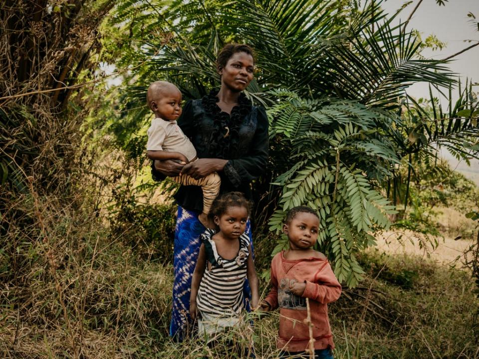 Mireille*, 29, poses for a portrait with her son Matisse*, 3 daughter Odette*, 5 and son Jules*,6 near their home (© Hugh Kinsella Cunningham / Save the Children)