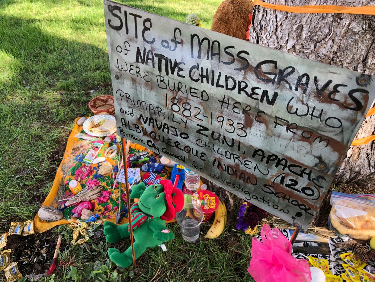 A memorial is shown for the dozens of Indigenous children who died more than a century ago while attending a boarding school that was once located nearby is growing under a tree at a public park in Albuquerque, N.M.