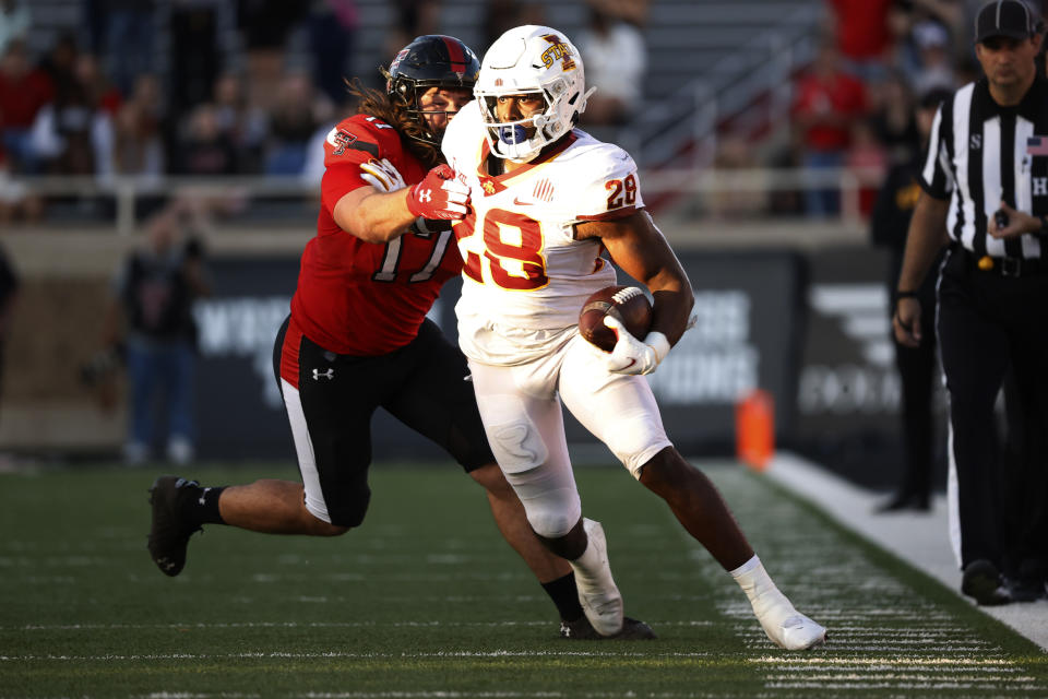 Iowa State's Breece Hall (28) tries to break away from Texas Tech's Colin Schooler (17) during the second half of an NCAA college football game Saturday, Nov. 13, 2021, in Lubbock, Texas. (AP Photo/Brad Tollefson)