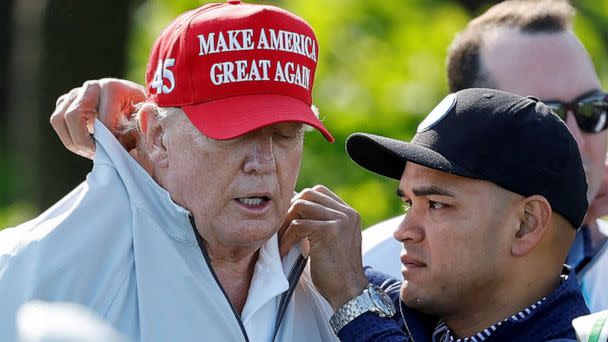PHOTO: FILE - Walt Nauta, personal aide to former U.S. President Donald Trump who faces charges of being Trump's co-conspirator in the alleged mishandling of classified documents, fixes Trump's collar before a LIV Golf Pro-Am golf tournament (Jonathan Ernst/Reuters, FILE)