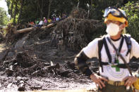 Un rescatista hace una pausa el viernes 30 de octubre de 2020 delante del tronco de un árbol que cayó durante un deslizamiento de tierra, en Nejapa, El Salvador. (AP Foto/Salvador Meléndez)
