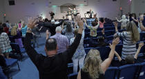 <p>Members of the Dayspring Church raise their hands in prayer Sunday, May 20, 2018, in Santa Fe, Texas. A gunman opened fire inside Santa Fe High School Friday, May 18, 2018, killing at least 10 people. (Photo: David J. Phillip/AP) </p>