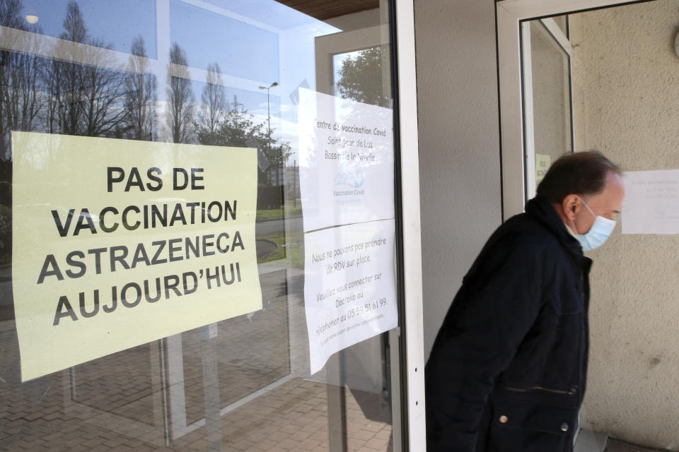 A man leaves a vaccination center while a poster reads "No vaccination with AstraZeneca vaccine today" in Saint-Jean-de-Luz, southwestern France, Tuesday, March 16, 2021. With coronavirus cases rising in many places, governments faced the grimmest of dilemmas Tuesday: push on with a vaccine that is known to save lives or suspend use of AstraZeneca over reports of dangerous blood clots in a few recipients, even as the European regulator said there was "no indication" the shot was responsible. (AP Photo/Bob Edme)