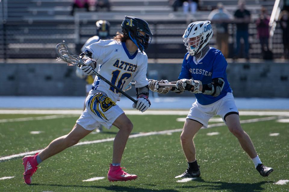 Assabet sophomore Liam Weagle brings the ball up the field under pressure from Worcester senior David Brissette during the game in Marlborough, May 6, 2021. The Aztecs beat Worcester, 12-6. 