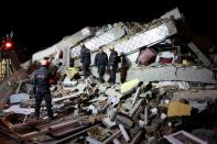 Rescue workers search on a collapsed building after an earthquake in Elazig