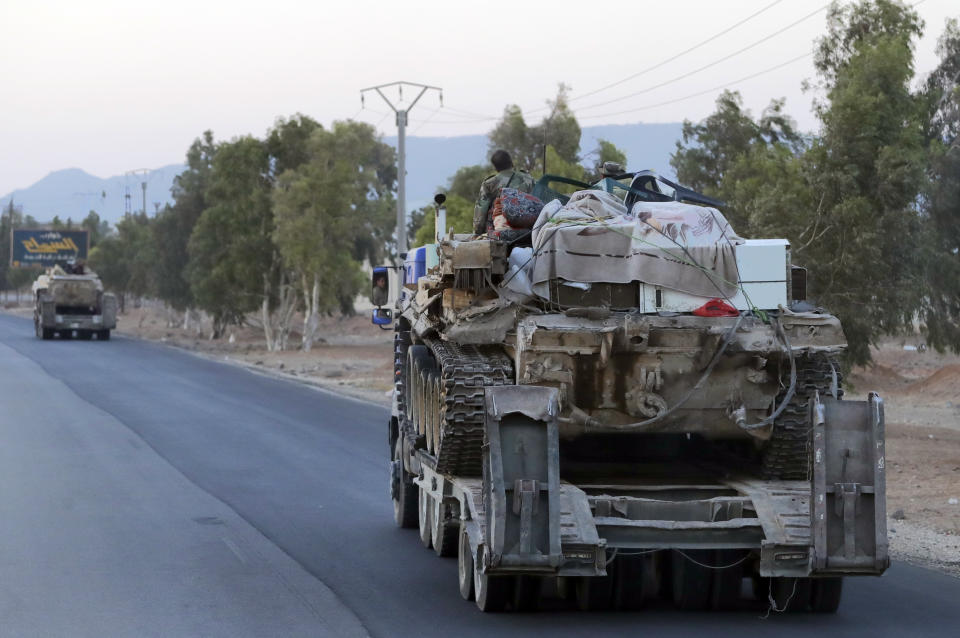 Syrian military move along a road near the village of Almajdiyeh, Syria, Tuesday, Aug. 14, 2018. The Russian military said Tuesday that its forces in Syria will help U.N. peacekeepers fully restore patrols along the frontier with the Israeli-occupied Golan Heights, reflecting Moscow's deepening role in mediating between the decades-old foes. (AP Photo/Sergei Grits)