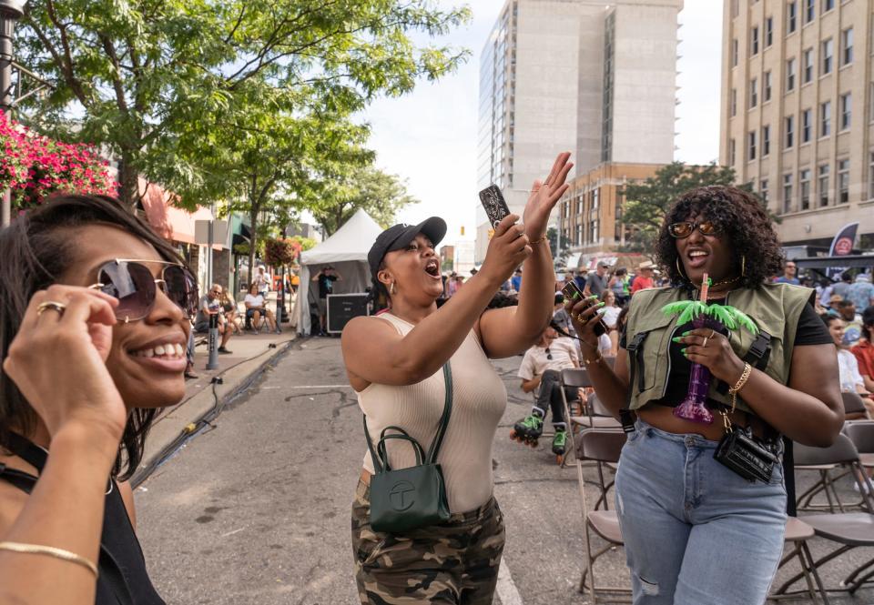 Takiyah Vincent, of Detroit, left, Siobhan Sims, of Detroit, and Ayia Banks, of Detroit, cheer on Aaron Lewys and his band as they play during Arts, Beats & Eats in downtown Royal Oak on Sept. 2, 2022.