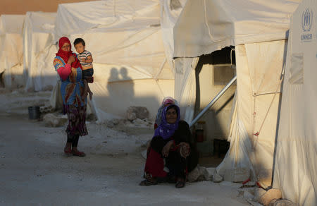 FILE PHOTO: An internally displaced woman sits outside a tent in Idlib province, Syria July 30, 2018. REUTERS/ Khalil Ashawi/File Photo