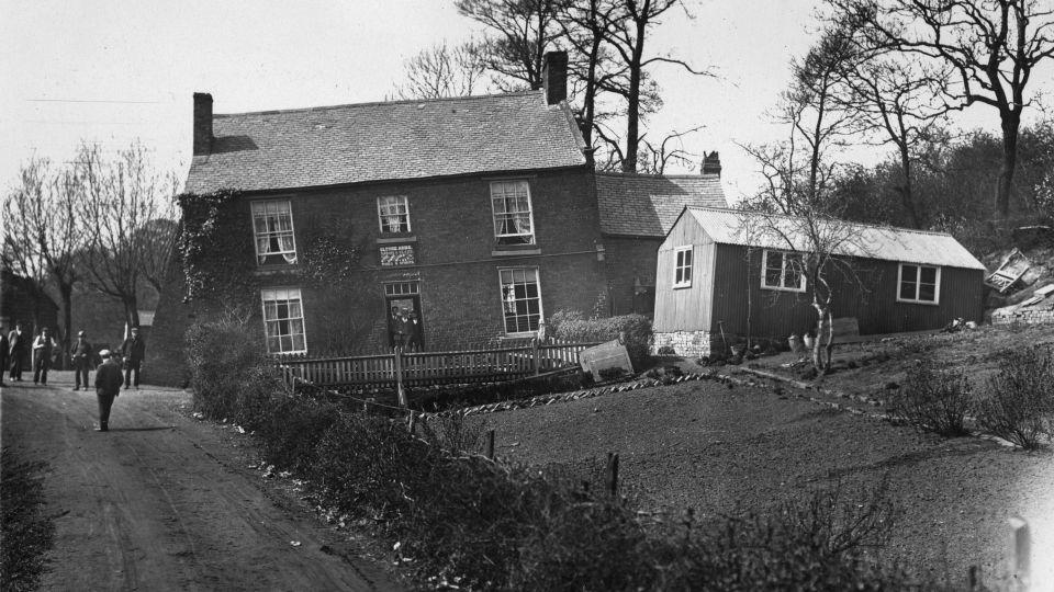 Formely known as The Glynne Arms, a crooked public house and outbuildings, leaning because of subsidence and soil erosion on 17th April 1907. - Topical Press Agency/Hulton Archive/Getty Images