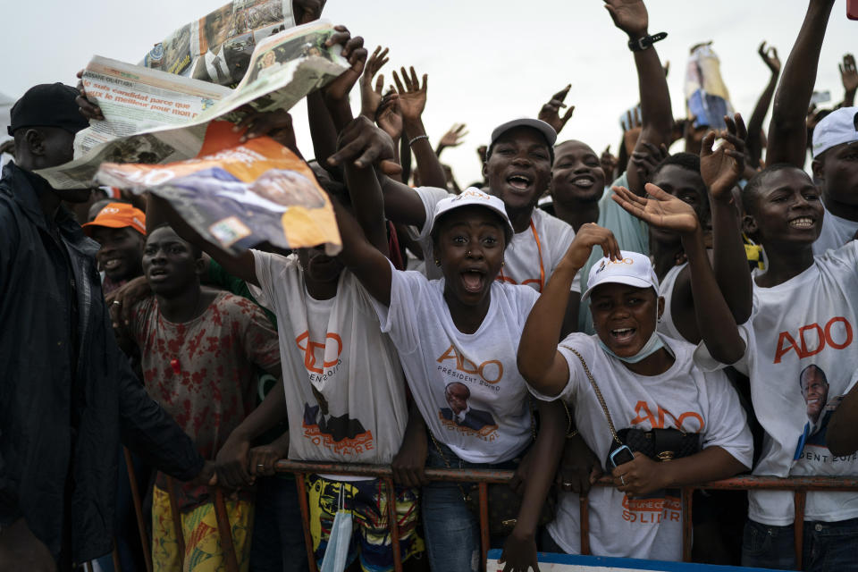 Supporters cheer as Ivory Coast President Alassane Ouattara arrives at a rally in Anyama, in the outskirts of Abidjan, Ivory Coast, Wednesday, Oct. 28, 2020. Ouattara, who first came to power after the 2010 disputed election whose aftermath left more than 3,000 people dead, is now seeking a third term in office. The candidate maintains that he can serve a third term because of changes to the country's constitution, though his opponents consider his candidacy illegal. (AP Photo/Leo Correa)