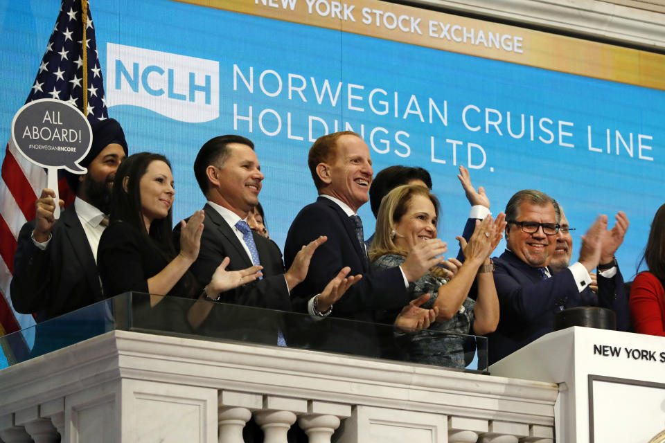 Norwegian Cruise Line Holdings President & CEO Frank Del Rio, right, joins applause as he rings the New York Stock Exchange opening bell, Tuesday, Nov. 12, 2019, to celebrate the launch of their newest ship, the Norwegian Encore. (AP Photo/Richard Drew)
