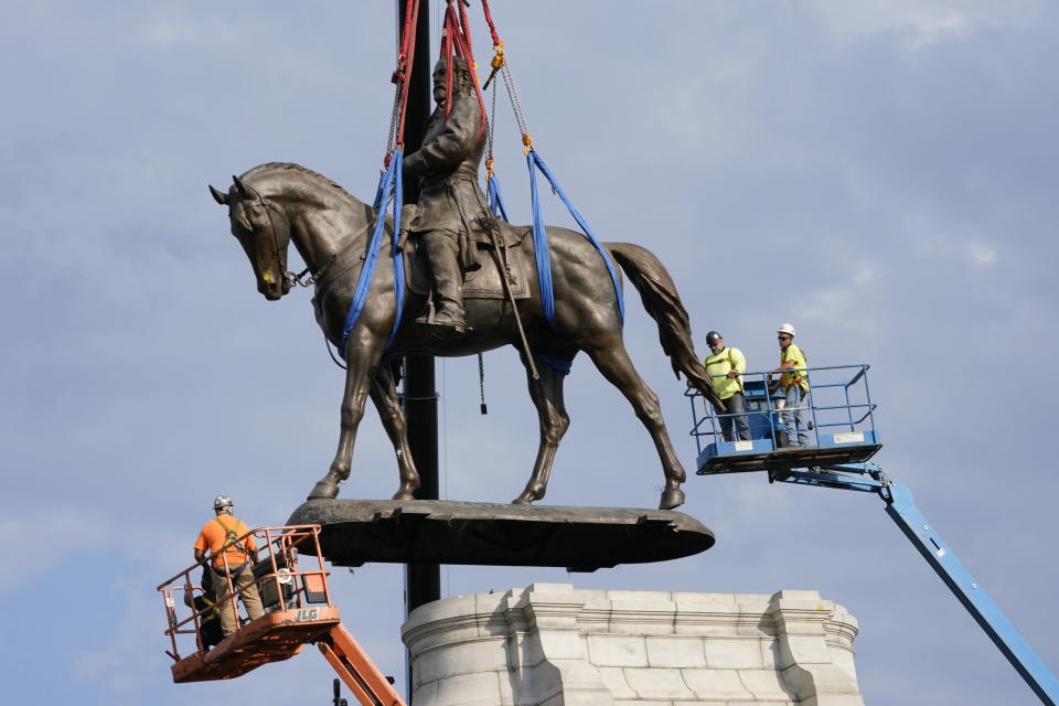 FILE - Crews remove one of the country's largest remaining monuments to the Confederacy, a towering statue of Confederate General Robert E. Lee on Monument Avenue in Richmond, Va., Wednesday, Sept. 8, 2021. The movement to identify and reckon with structural racism moved forward in 2021. As local and state governments grappled with the removal of statues of racist historical figures, local school boards fought over how to teach the uneasy history of racism in the United States. (AP Photo/Steve Helber, File)