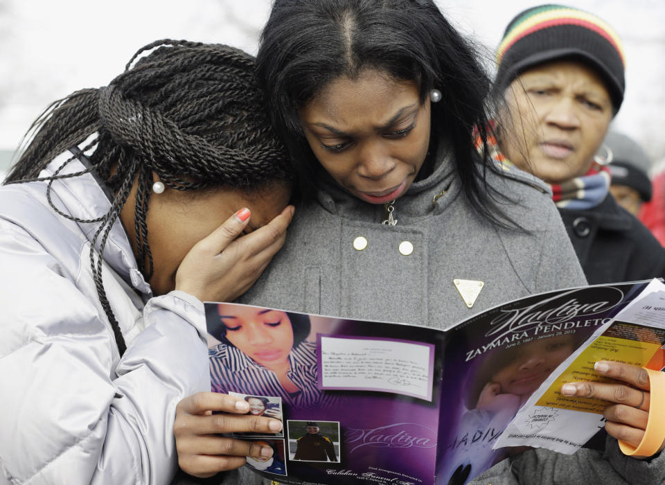 FILE - In this Feb. 9, 2013 file photo, Danyia Bell, 16, left, and Artureana Terrell, 16, react as they read a program after the funeral service for 15-year-old Hadiya Pendleton outside the Greater Harvest Missionary Baptist Church in Chicago. Hundreds of mourners and dignitaries including first lady Michelle Obama packed the funeral service for the Chicago teen whose killing catapulted her into the nation's debate over gun violence. Since her death, the number of homicides and other violent crimes that turned Chicago into a national symbol of gun violence have fallen sharply after the city and police changed strategies. (AP Photo/Nam Y. Huh, File)