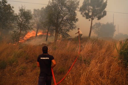 Villagers help to put out a forest fire at the village of of Colos