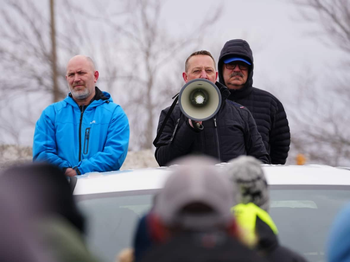 Jason Spingle, John Efford Jr. and Greg Pretty address a crowd of fish harvesters on Friday afternoon, telling them a deal had been reached with the provincial government to end days of protests. (Ryan Cooke/CBC - image credit)