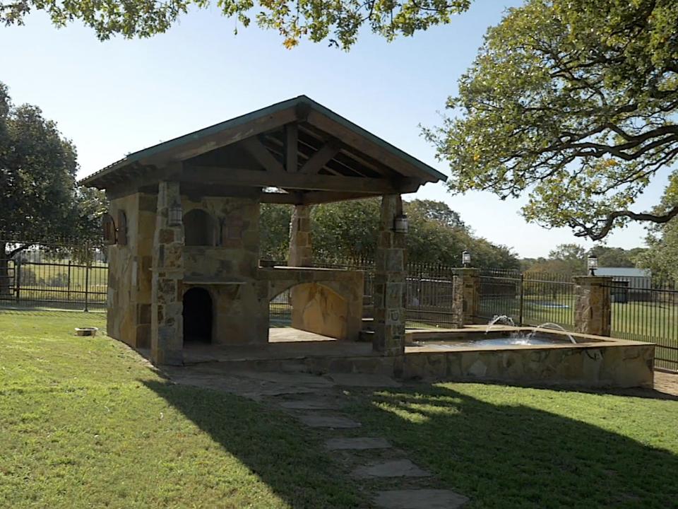A two-story, stone dog house with a fountain is on Terry Bradshaw's ranch property.