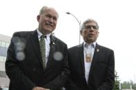 Alaska Gov. Bill Walker, left, and Lt. Gov. Byron Mallott speak in a rainy outdoors news conference in Anchorage, Alaska, Monday, Aug. 20, 2018, after the two men submitted signatures to get their ticket on the November general election ballot. Walker is an independent and Mallott is a Democrat, and they decided to gather signatures to advance to the November election instead of taking part in the primary election on Aug. 21. (AP Photo/Mark Thiessen)