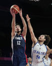 France's Nando de Colo (12) scores over Italy's Alessandro Pajola (54) during a men's basketball quarterfinal round game at the 2020 Summer Olympics, Tuesday, Aug. 3, 2021, in Saitama, Japan. (AP Photo/Eric Gay)