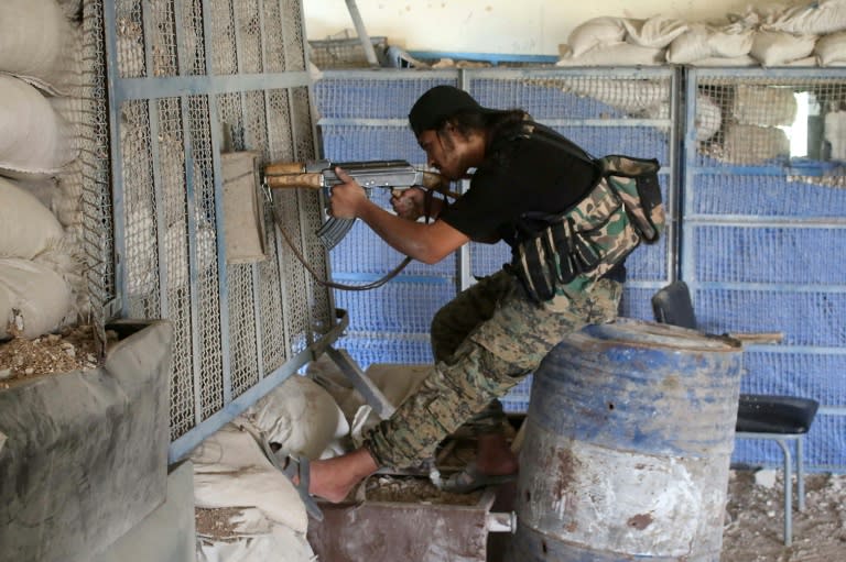 A Syrian rebel fighter aims his AK-47 in a fortified area near the frontlines at a rebel-held area in the southern Syrian city of Daraa on June 3, 2018