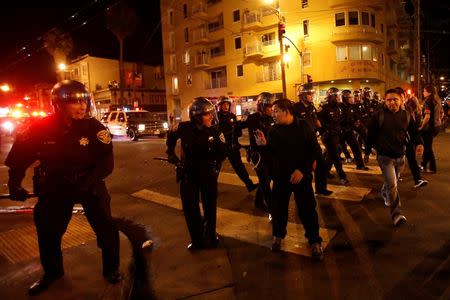 Police officers disperse a crowd in the Mission District, in San Francisco, California October 29, 2014. REUTERS/Stephen Lam