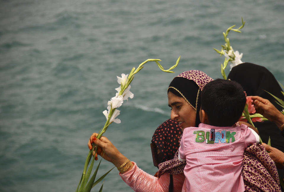 FILE - In this July 3, 2011 file photo, an Iranian woman scatters flower into the Persian Gulf at the site where an Iranian passenger plane was downed by a U.S. warship, killing all 290 aboard. The Western allegation that Iran shot down a Ukrainian jetliner and killed 176 people offers a grim echo for the Islamic Republic, which found itself the victim of an accidental shootdown by American forces over 30 years ago. (AP Photo/Ali Hashemi, File)