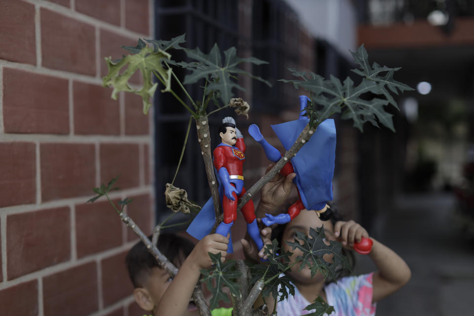 Children play with "Super Bigote" or Super Mustache dolls in the Carayaca neighborhood of La Guaira , Venezuela, Tuesday, Dec. 27, 2022. The delivery of toys of "Super Bigote" and "Cilita" dolls based on the image of Venezuelan President Nicolas Maduro and his wife Cilia Flores, were handed to thousands of children this Christmas, causing controversy among some Venezuelans. (AP Photo/Jesus Vargas)