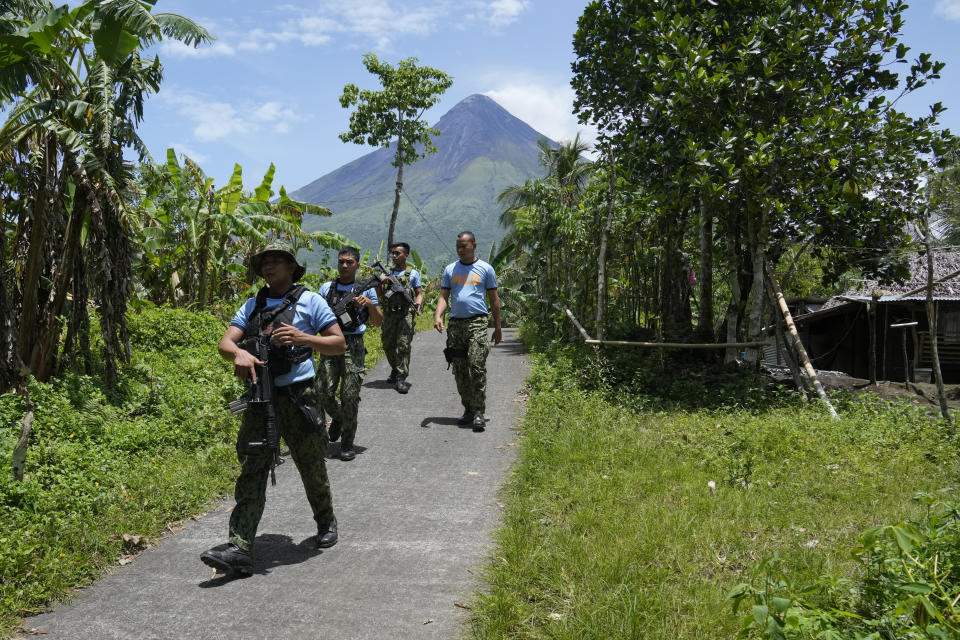 Police conduct an inspection inside the "permanent danger zone" to check for evacuees returning or still staying at their homes at Calbayog village in Malilipot town, Albay province, northeastern Philippines, Thursday, June 15, 2023. Thousands of residents have left the mostly poor farming communities within a 6-kilometer (3.7-mile) radius of Mayon's crater in forced evacuations since volcanic activity spiked last week. (AP Photo/Aaron Favila)