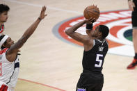 Sacramento Kings guard De'Aaron Fox (5) shoots for a basket against Washington Wizards guard Bradley Beal, left, during the closing seconds of an NBA basketball game, Wednesday, March 17, 2021, in Washington. This basket put the Kings up. The Kings won 121-119. (AP Photo/Nick Wass)