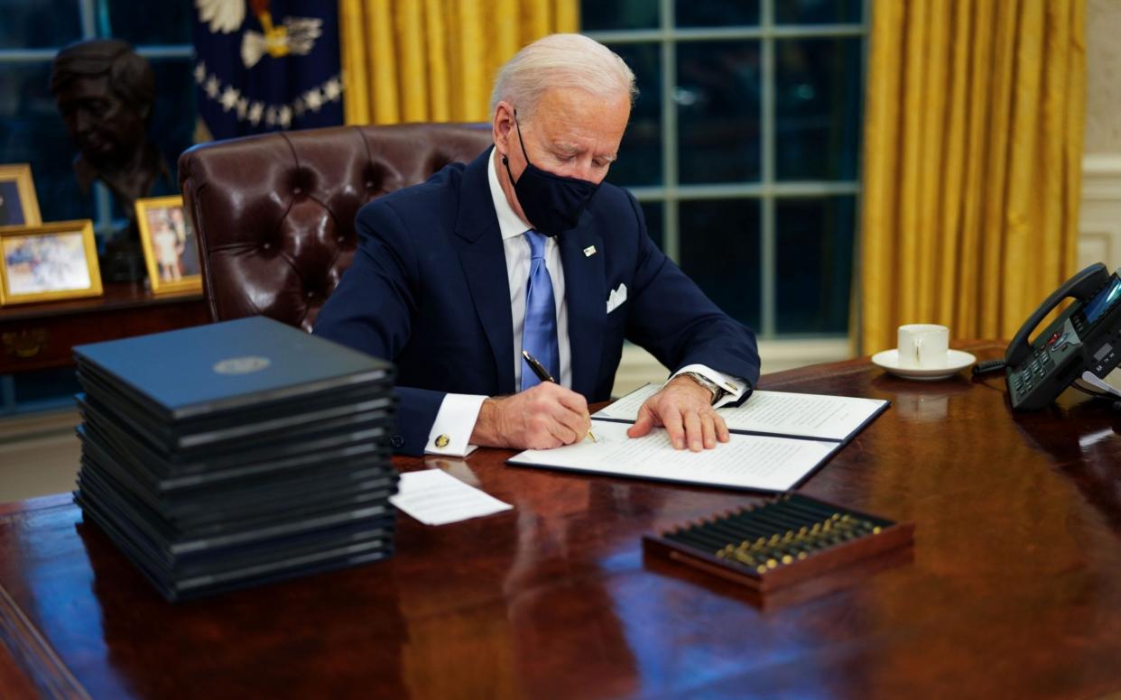 US President Joe Biden signs executive orders during his first minutes in the Oval Office, Washington, Usa - 19 Jan 2021 - EPA