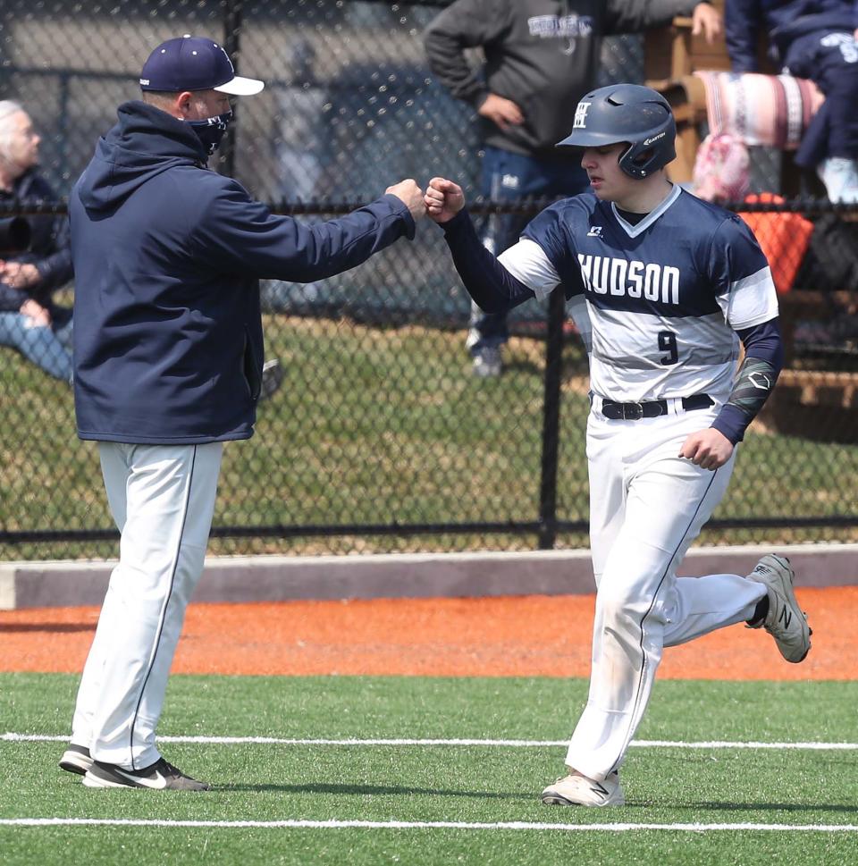 Hudson head coach Buddy Dice, left, fist bumps Sam Scharville after his two-run homer in the seventh inning of a home game against Wooster, April 3, 2021.
