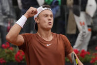Denmark's Holger Rune celebrates after winning the quarter final match against Serbia's Novak Djokovic at the Italian Open tennis tournament, in Rome, Wednesday, May 17, 2023. (AP Photo/Gregorio Borgia)