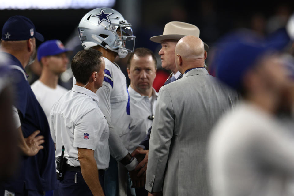 ARLINGTON, TEXAS - SEPTEMBER 11: Dak Prescott #4 of the Dallas Cowboys has his hand examined by team surgeon Dr. Dan Cooper during the second half of the NFL game against the Tampa Bay Buccaneers  at AT&T Stadium on September 11, 2022 in Arlington, Texas. (Photo by Tom Pennington/Getty Images)