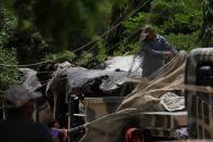 Workers cover a truck with the wreckage of the crashed plane, in Karachi